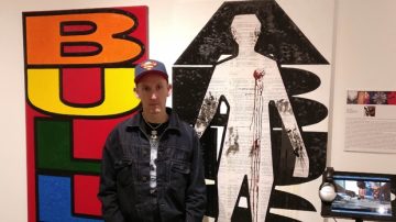 Jason Henriksen stands in front of his work in the exhibit "Still Here" at Vancouver's Gallery Gachet. Nov. 6, 2016. Photo from CTV Vancouver